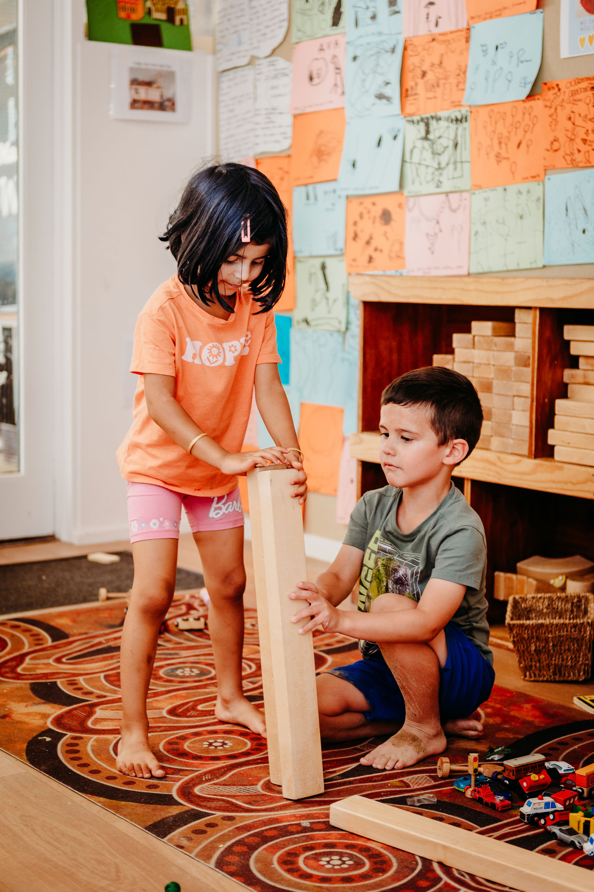 Two children playing with wooden blocks.